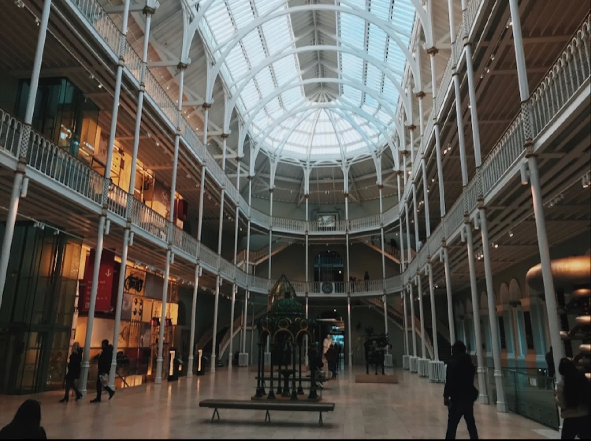 A spacious interior of a building featuring a striking glass ceiling that allows natural light to illuminate the space.